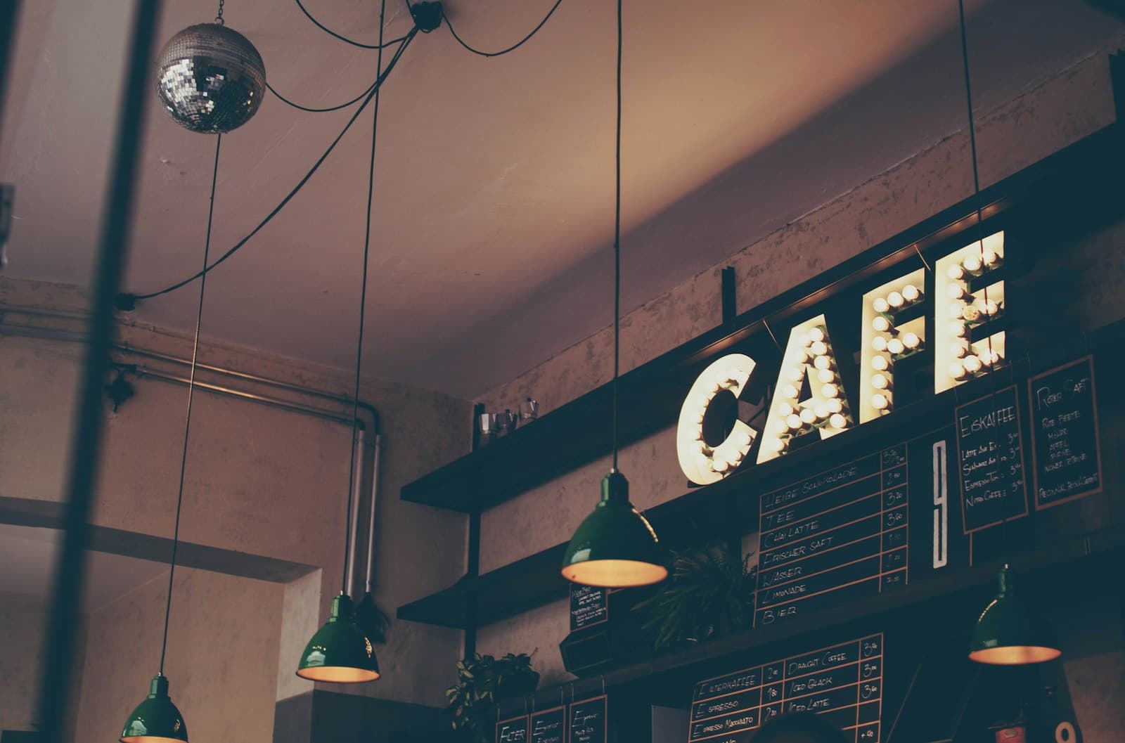 A café counter with menu boards and an illuminated sign