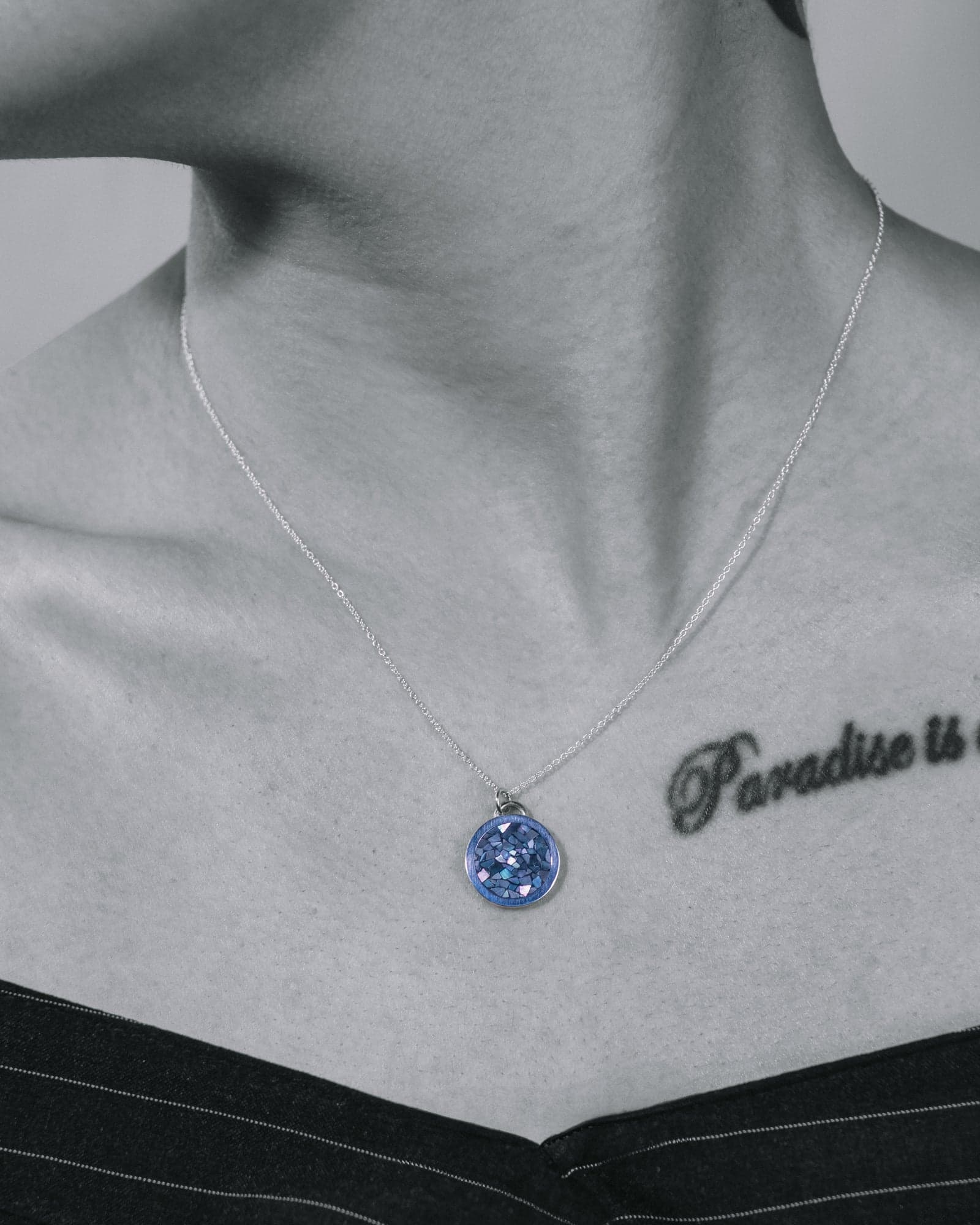 Black-and-white campaign shot of the circle pendant worn at the collarbone