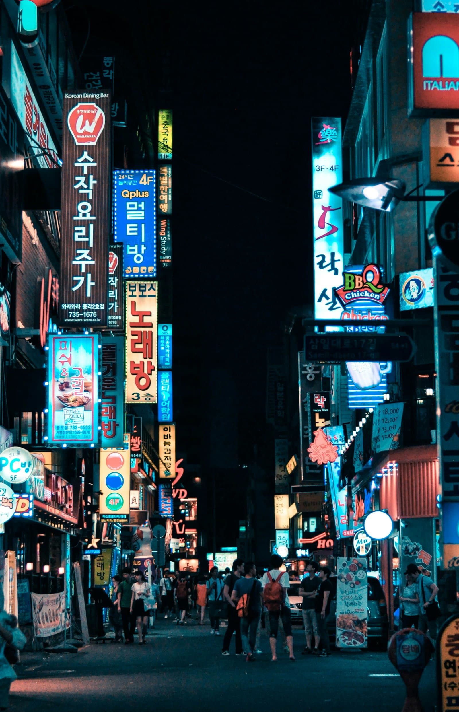 A Seoul street at night under stacked neon signage